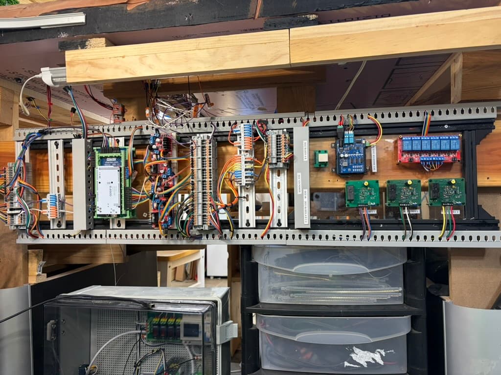 DIN-rail Digital Dispatcher installed under my own layout, with a command station, driver boards, a relay board, and labeled terminal blocks