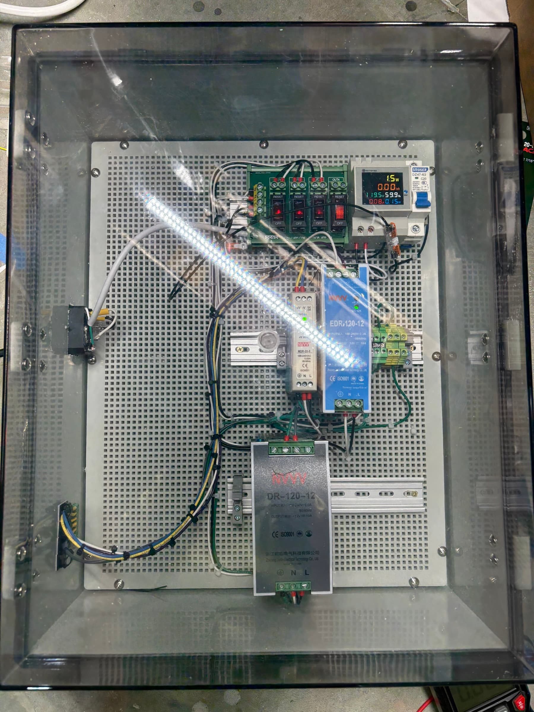 Clear-lid power cabinet with DIN-rail power supplies and a live power meter