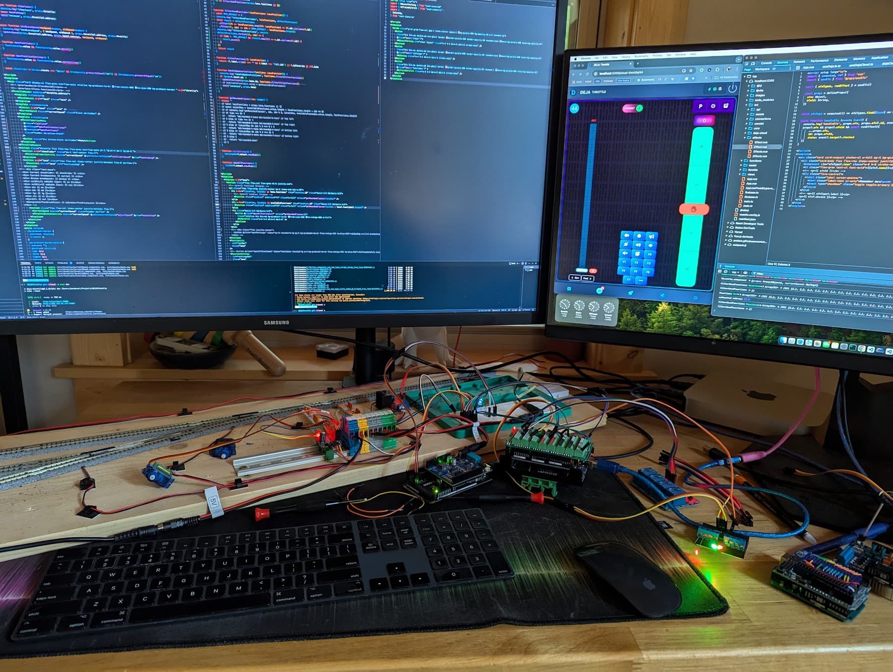 My test bench: DEJA Throttle on screen, driving servo turnouts, relays, and terminal blocks wired to a test track